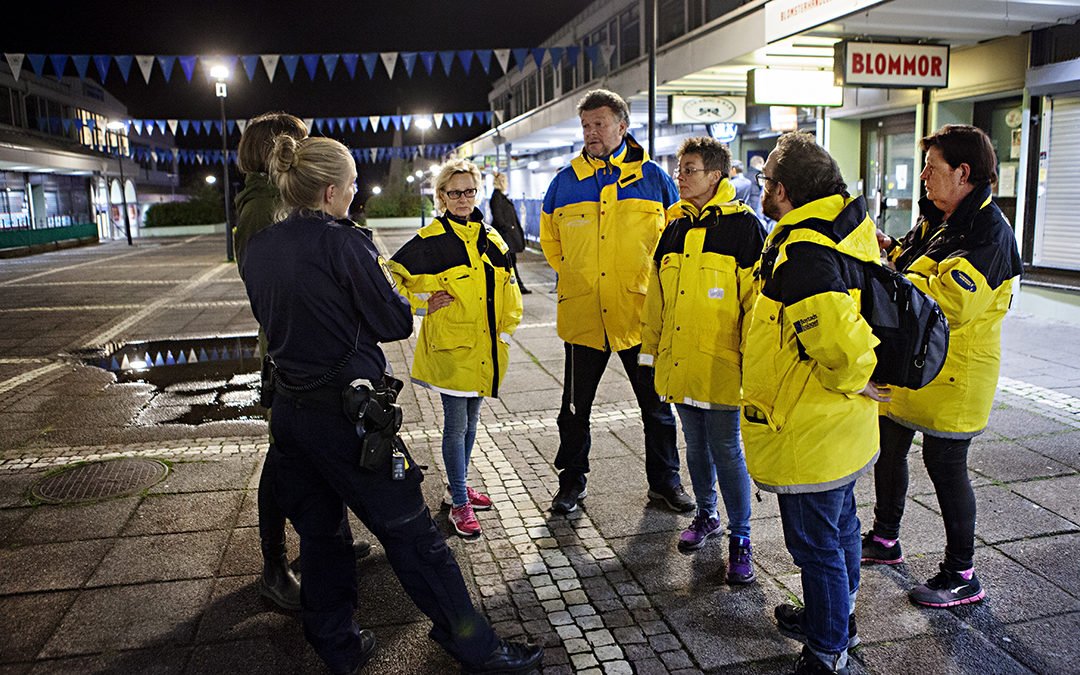 Nattvandrarna pratar med polisen på Vårväderstorget.