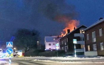 Bilden visar branden på avstånd. Eldslågor slår upp från huset.