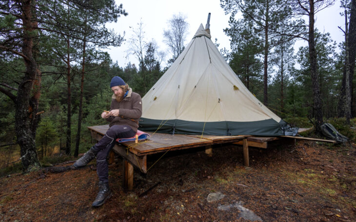 Erik Isidorsson bor i ett tält i skogen sedan nästan ett år. Inga bekvämligheter bara naturen och djuren inpå tältduken. Fritidssysselsättningen är musik och att tälja schackpjäser.