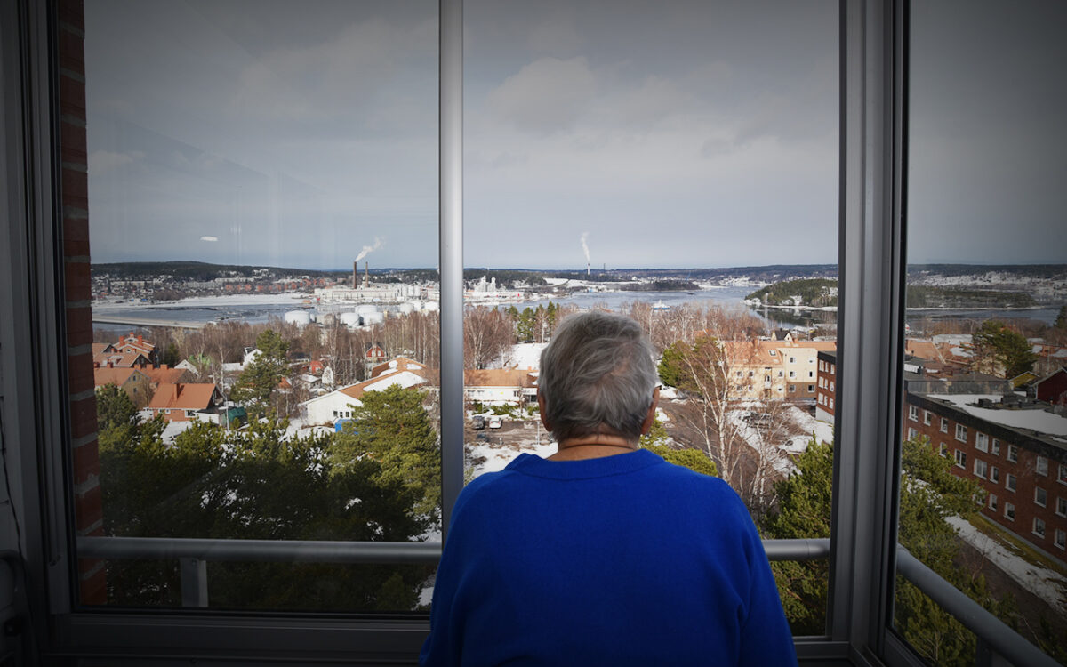 Ryggtavlan av en person som står och tittar ut från en högt belägen balkong.