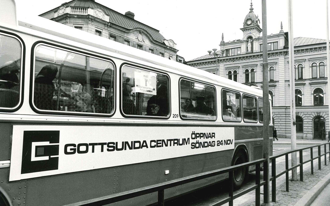En svartvit bild från 1970-talet. En stadsbuss i Uppsala gör reklam för Gottsunda centrum.