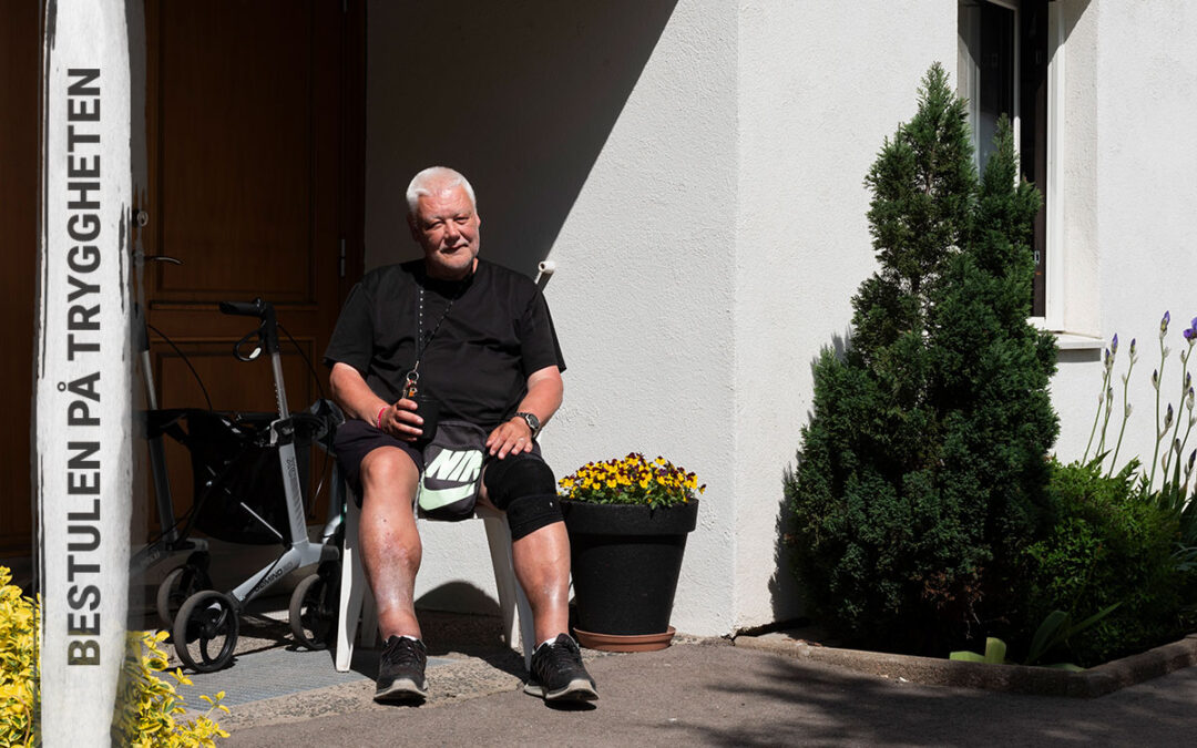 En äldre man med kortklippt vitt hår och svart t-tröja som sitter och dricker kaffe ur en mugg utanför en port och i bakgrunden syns en rullator och text på bilden "Bestulen på tryggheten".