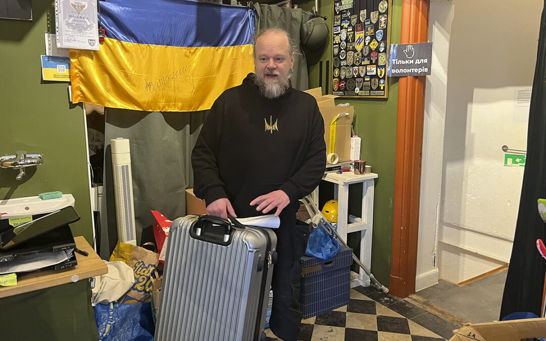 Mankan Thorneus i mörka kläder lyfter en resväska inne på å Refugee Support Uppsalas humanitära hjälpcenter på Norrtäljegatan. Flyktingar från Ukraina har haft svårt att klara chockhöjda hyror och retroaktiv hyra.