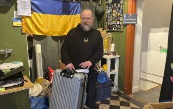 Mankan Thorneus i mörka kläder lyfter en resväska inne på å Refugee Support Uppsalas humanitära hjälpcenter på Norrtäljegatan. Flyktingar från Ukraina har haft svårt att klara chockhöjda hyror och retroaktiv hyra.