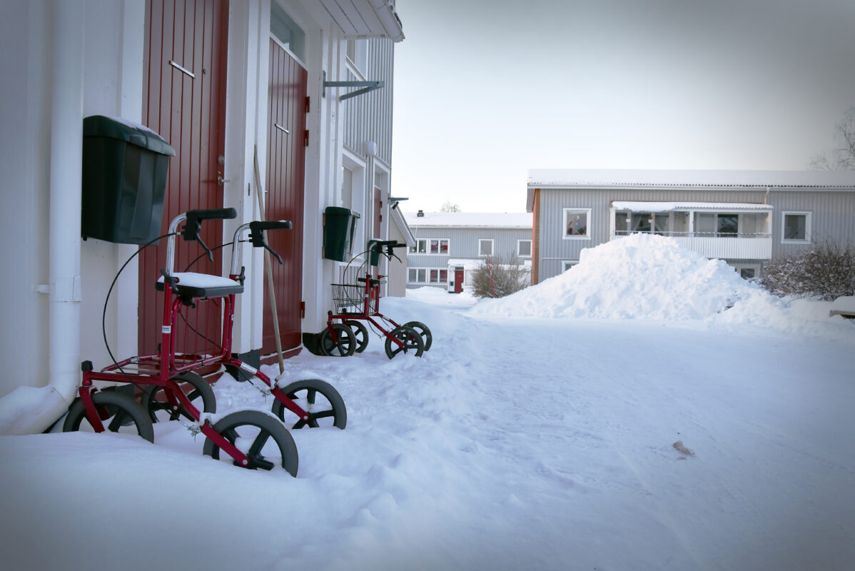 En rad parkerade rollatorer utomhus i snölandskap.