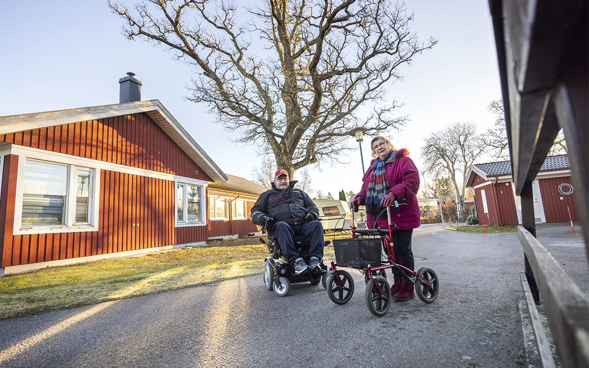 Man i svart jacka och röd keps, i elrullstol. Kvinna i grå page och vinröd kappa, med rollator. Hyresgäster i Herräng har tröttnat på problemen med hyresvärden AB-hem.