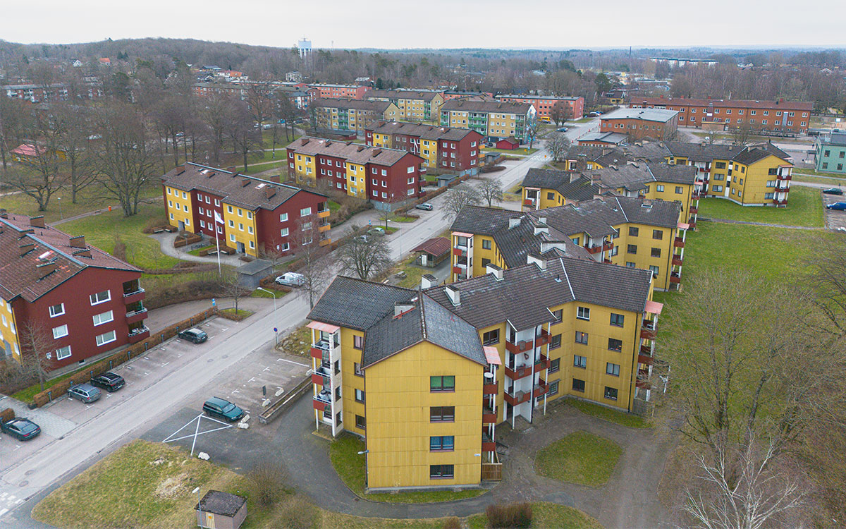 Ett foto taget ovanifrån som visar flera sammanbyggda, gula fyravångshus som bildar ett stjärnmönster.